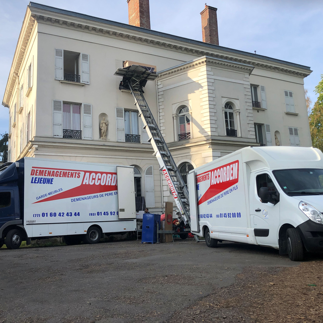 Camion et utilitaire Accordem en intervention avec un monte-meubles devant un immeuble lors d’un déménagement
