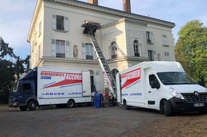 Camion et utilitaire Accordem en intervention avec un monte-meubles devant un immeuble lors d’un déménagement